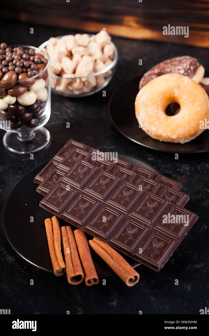 Top view of chocolate tablets, donuts, brown sugar with peanuts in