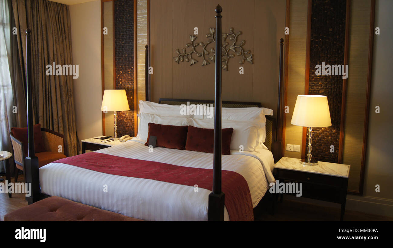 PULAU LANGKAWI, MALAYSIA - APR 4th 2015: Comfy bed in a luxury hotel suite at THE DANNA, colonial room design. Stock Photo
