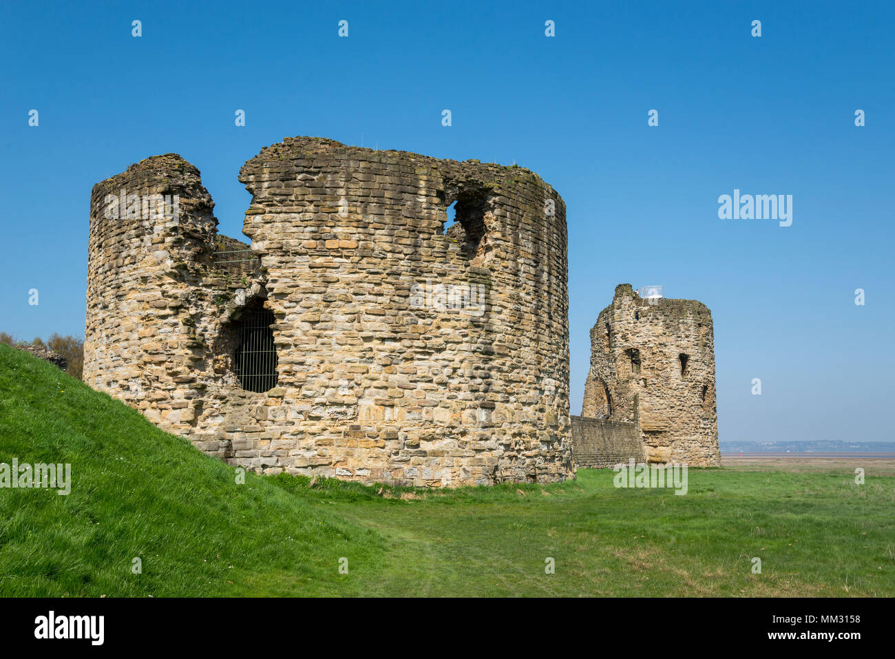 Ruins of Flint Castle beside the river Dee in Flintshire, North Wales. Circular 'Donjon' tower in the foreground. Stock Photo