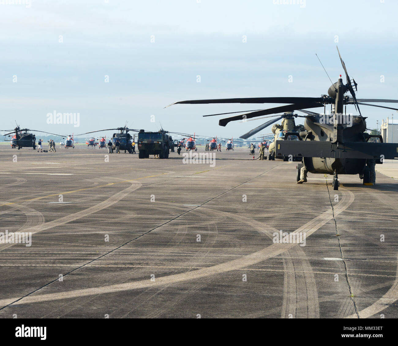 Helicopters from the National Guard and U.S. Coast Guard sit on the