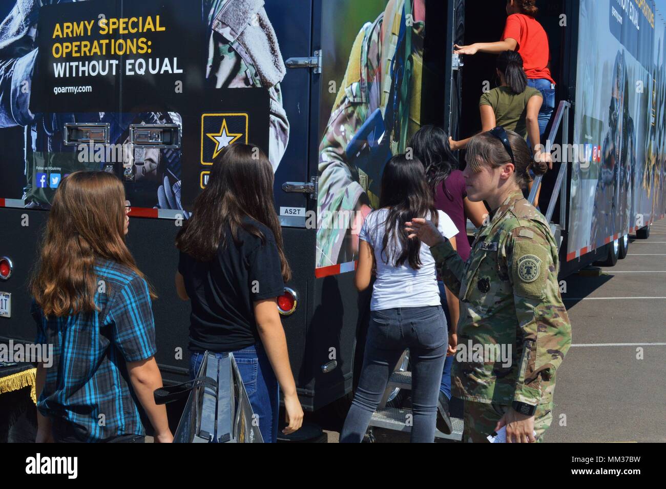 Staff Sgt. Jennifer Kirim (right), center leader, Black Canyon Recruiting Center, guides students from Moon Valley High School into an interactive Special Operations Semi (AS2) tractor-trailer, Sept. 5, Moon Valley High School, Phoenix. The event was hosted by recruiters from Phoenix North Recruiting Company, Phoenix Recruiting Battalion, who guided hundreds of students through the trailer, allowing them to witness and experience aspects of the Special Operations world. The AS2 features a host of exhibits, including a Parachute Simulator, AH6 Little Bird Simulator, Weapons Display and a Ground Stock Photo
