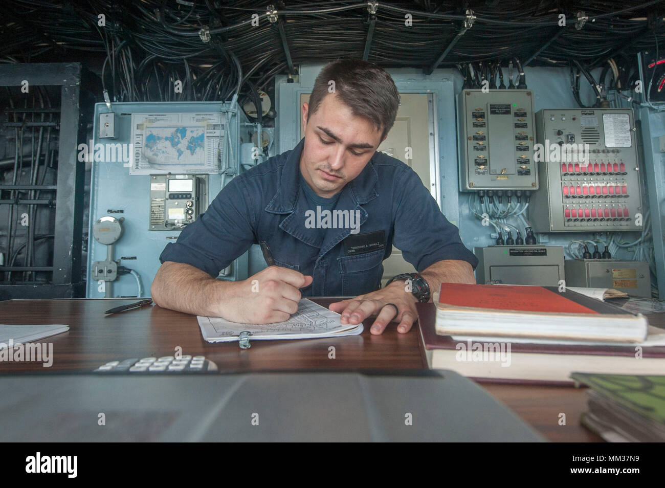 170901-N-ZS023-025 INDIAN OCEAN (Sept. 1, 2017) Quartermaster Seaman Theodore Schulz, a native of Berryville, Virginia, assigned to the navigation department aboard the amphibious assault ship USS America (LHA 6), logs the ship’s bearing in the ship’s bridge while on watch. America, part of the America Amphibious Ready Group, with embarked 15th Marine Expeditionary Unit, is operating in the Indo-Asia Pacific region to strengthen partnerships and serve as a ready-response force for any type of contingency.  (U.S. Navy photo by Mass Communication Specialist Seaman Vance Hand/Released) Stock Photo
