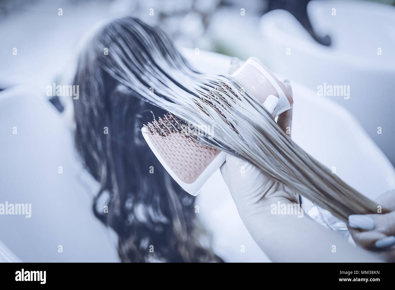 girl in a beauty salon. wash your hair, hair care, health. Toned image. Combing of washed hair with a special comb in the hairdresser's. Stock Photo