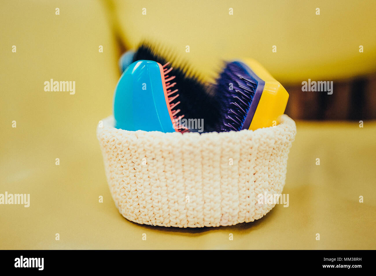 Basket with combs and round hair brushes. Toned image. Comb for combing raw hair in a basket in a hair salon. close up view Stock Photo