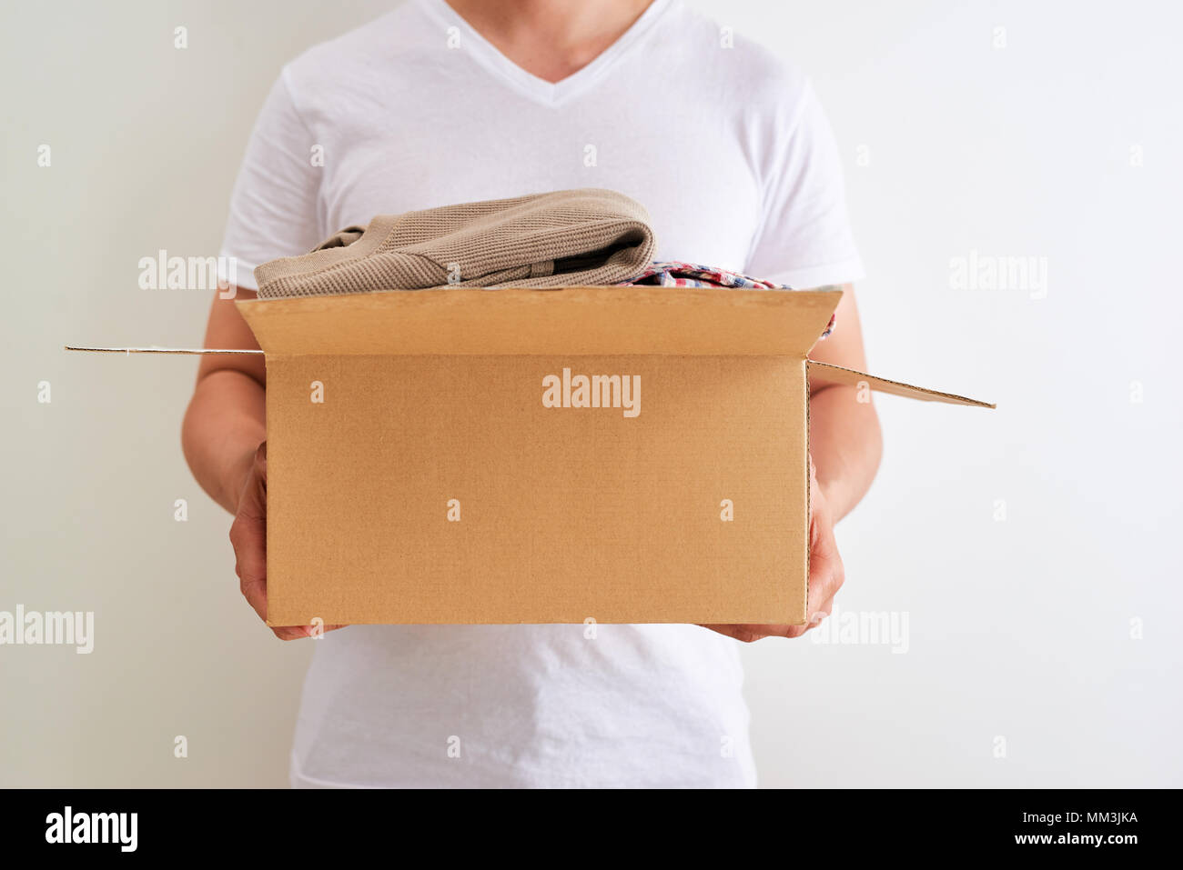 Man holding a clothes donate box. Donation concept Stock Photo Alamy