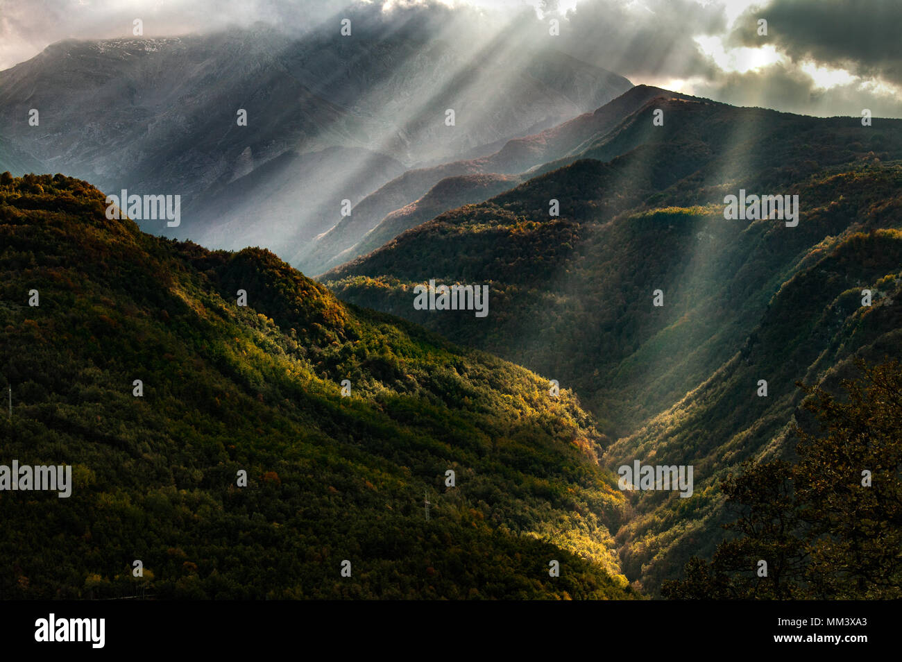 sunrays filter through the clouds in a mountainous valley, Gran Sasso and Monti della Laga National Park, Abruzzo, Italy Stock Photo