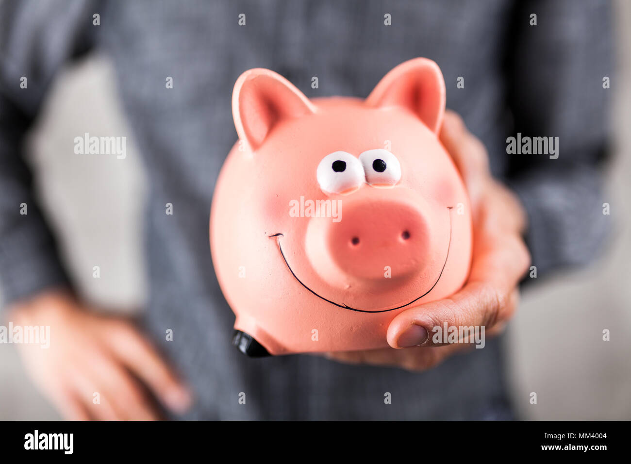 Man holding a piggy bank Stock Photo - Alamy