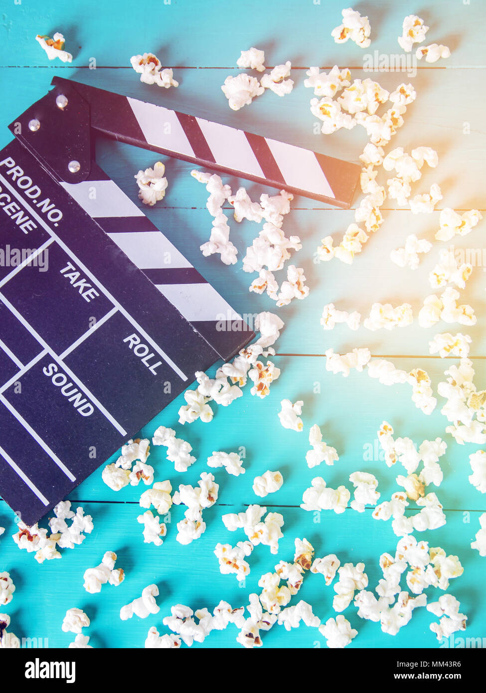 Popcorn and clapperboard on colorful blue background Stock Photo