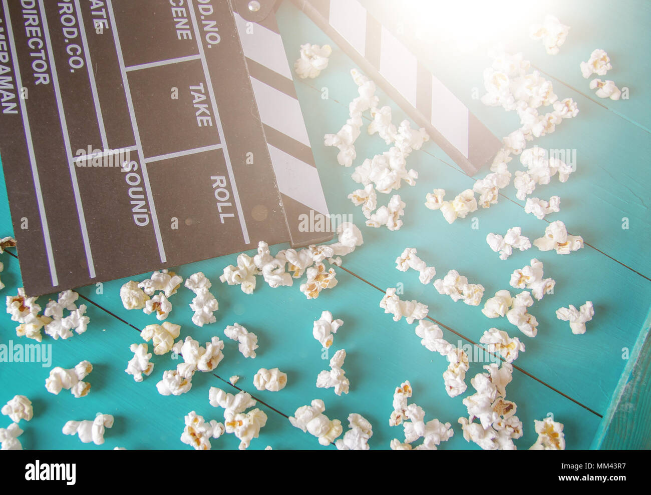 Popcorn and clapperboard on colorful blue background Stock Photo