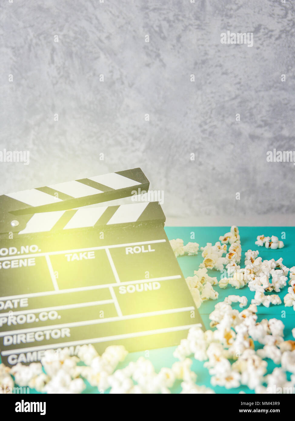Popcorn and clapperboard on colorful blue background Stock Photo