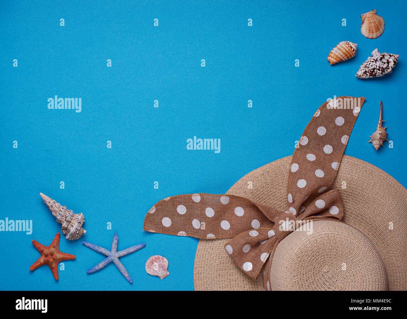 Straw hat and seashells on blue background Stock Photo - Alamy
