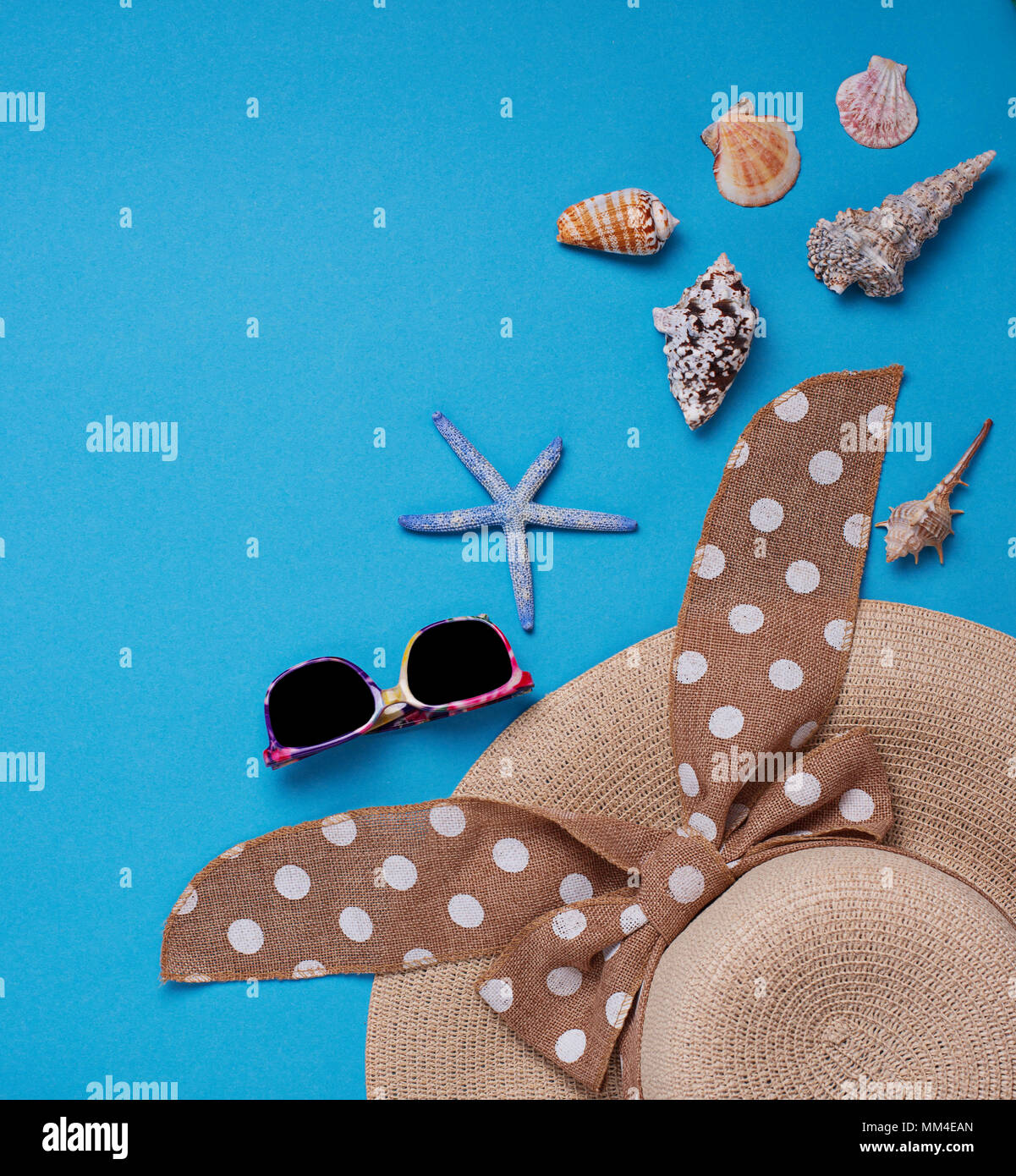 Straw  hat and seashells on blue background Stock Photo