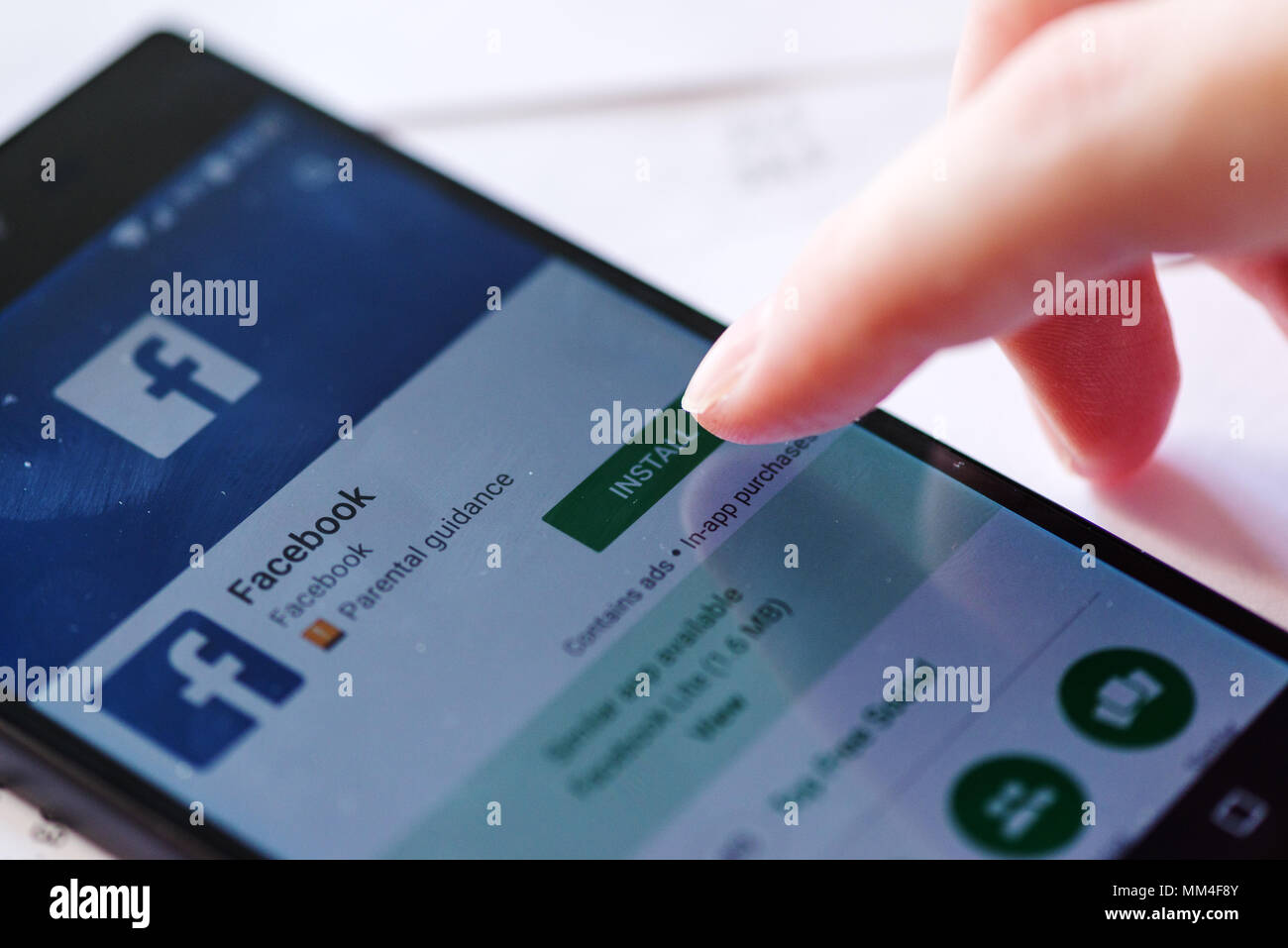 NOVI SAD, SERBIA - MAY 8, 2018: Installing Facebook app for Android smartphones on Sony Experia Z5 mobile from Google Play Store. This application has Stock Photo