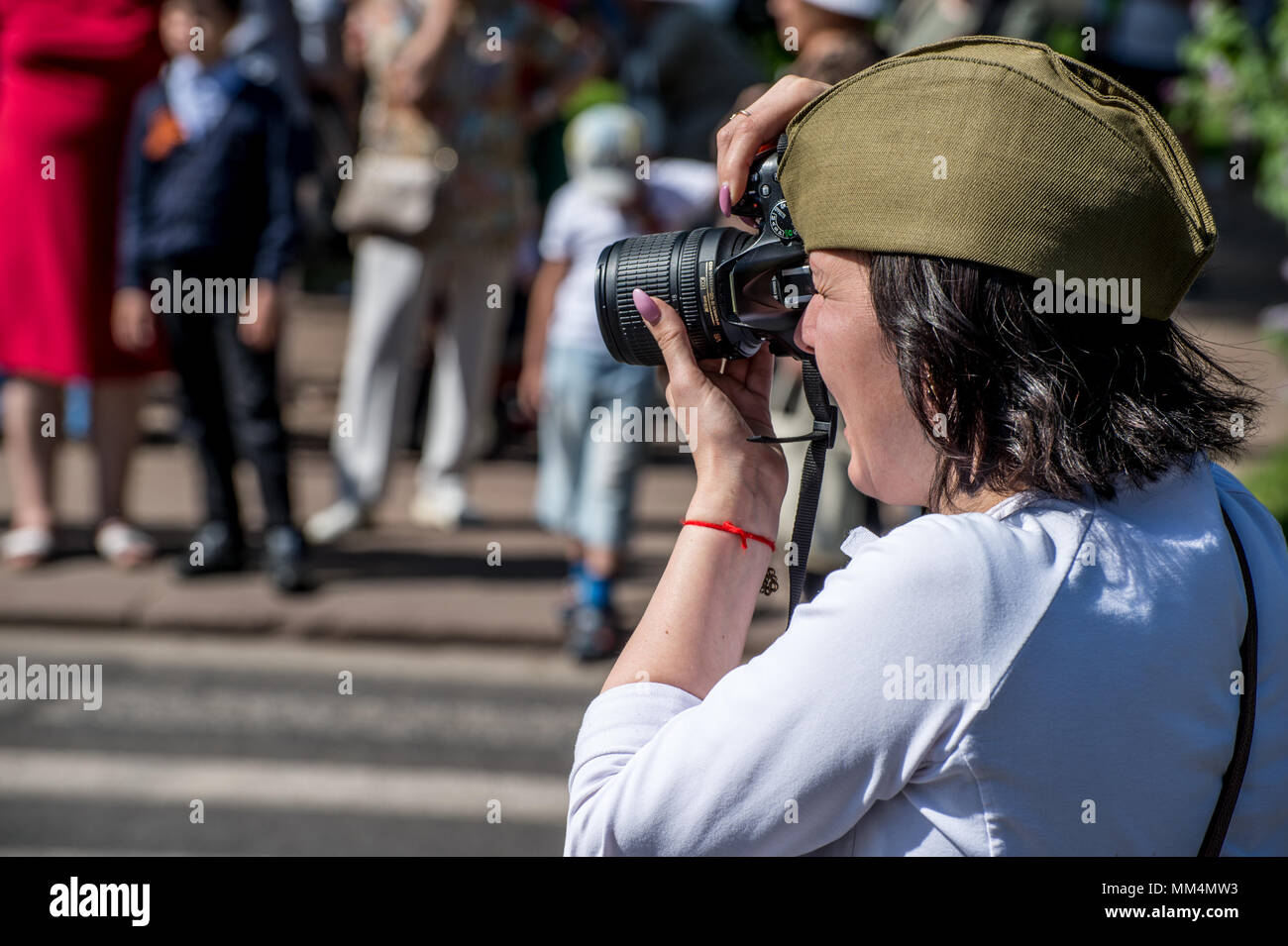 KURSK REGION, ZHELEZNOGORSK, RUSSIA - May 9, 2018. dark-haired Russian girl in a military green cap draws a parade Immortal Regiment with portraits of Stock Photo