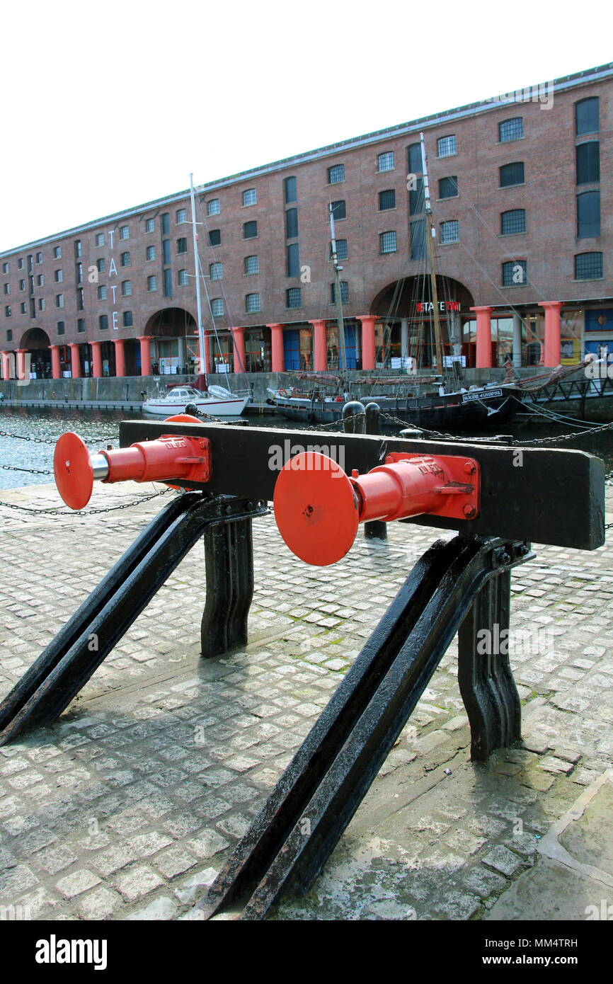 disused railway buffers at the albert dock liverpool painted red with dock warehouse buildings in background Stock Photo