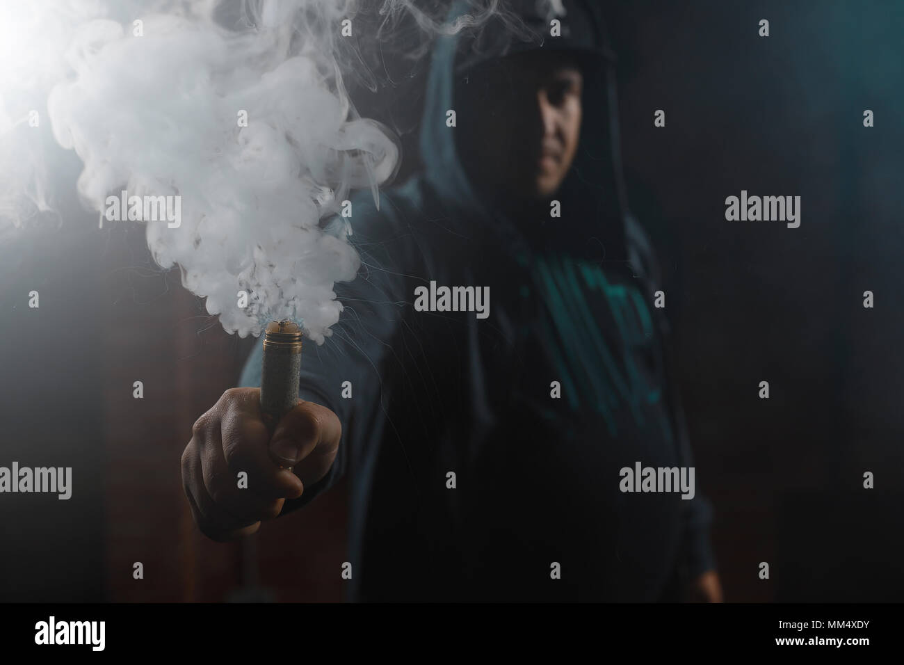 Dripper in one hand making a cloud of white, blue vapours. Friendly for