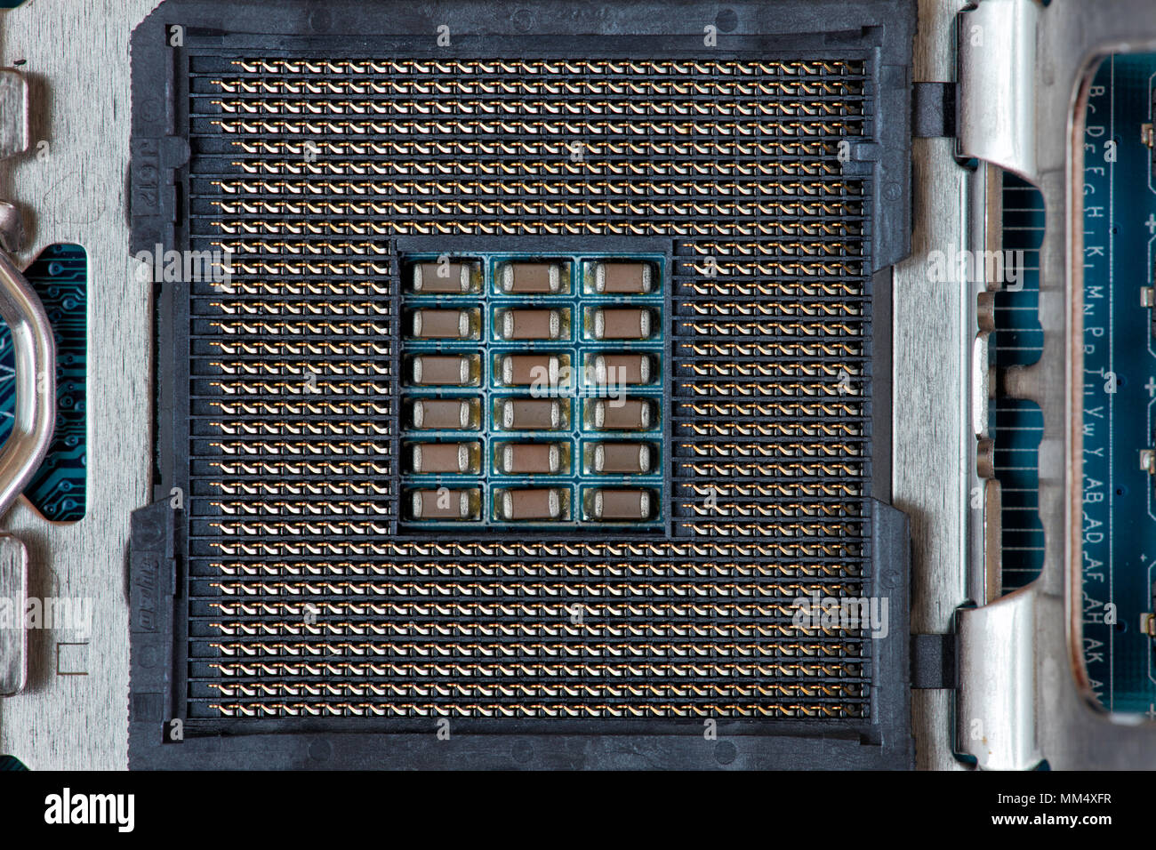 Electrical contacts (pins) in Intel LGA1150 processor socket with retention clip open. Stock Photo