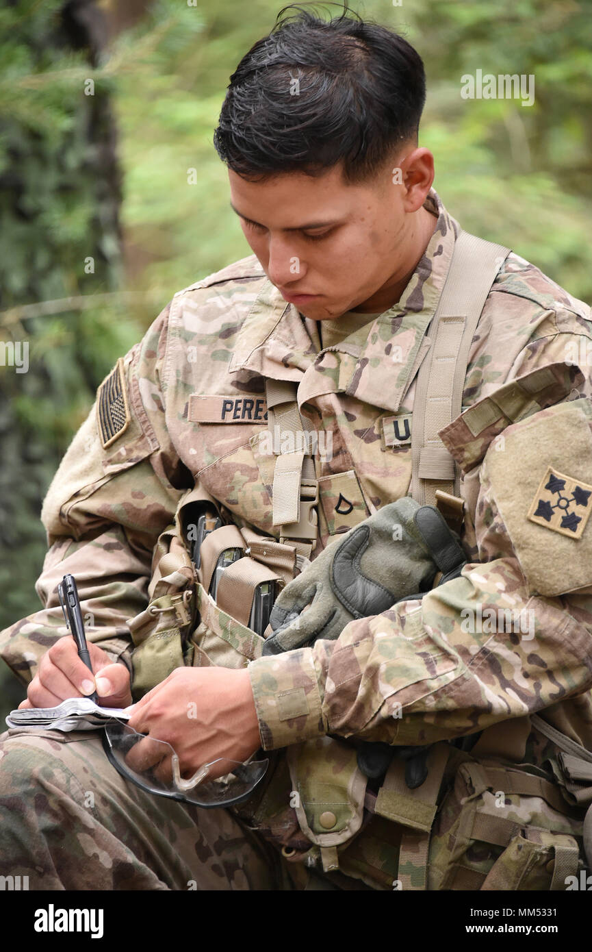 U.S. Army Pfc. Joel Perez with Headquarters and Headquarters Company, 1st Battalion, 68th Armor Regiment, 3rd Armored Brigade Combat Team, 4th Infantry Division, takes notes during the 2nd Cavalry Regiment’s Expert Infantryman Badge competition training phase at the 7th Army Training Command’s Grafenwoehr Training Area, Germany, Sept. 6, 2017. Stock Photo