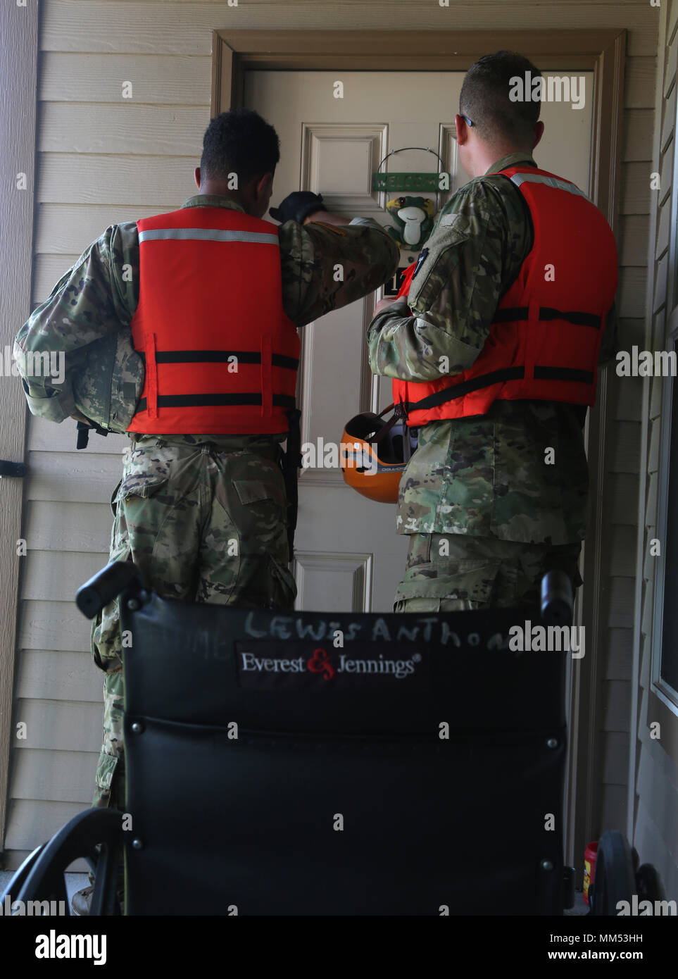 U.S. Army Pvt. Eddie Adams, left, and Spc. James Zuehlke, right, Cavalry Scouts, assigned to 1-124 Cavalry of the Texas National Guard, knock on someone's door during a health and welfare patrol in Orange, Texas, Sept. 5, 2017. The U.S. Military and relief agencies continue to assist in aiding those affected by Hurricane Harvey.  (U.S. Army photo by Spc. Elizabeth Brown) Stock Photo