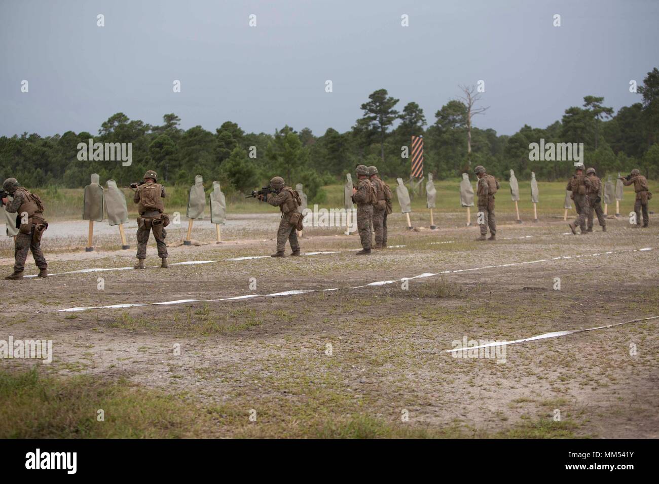 Marines fire their weapons at targets at close range during a combat