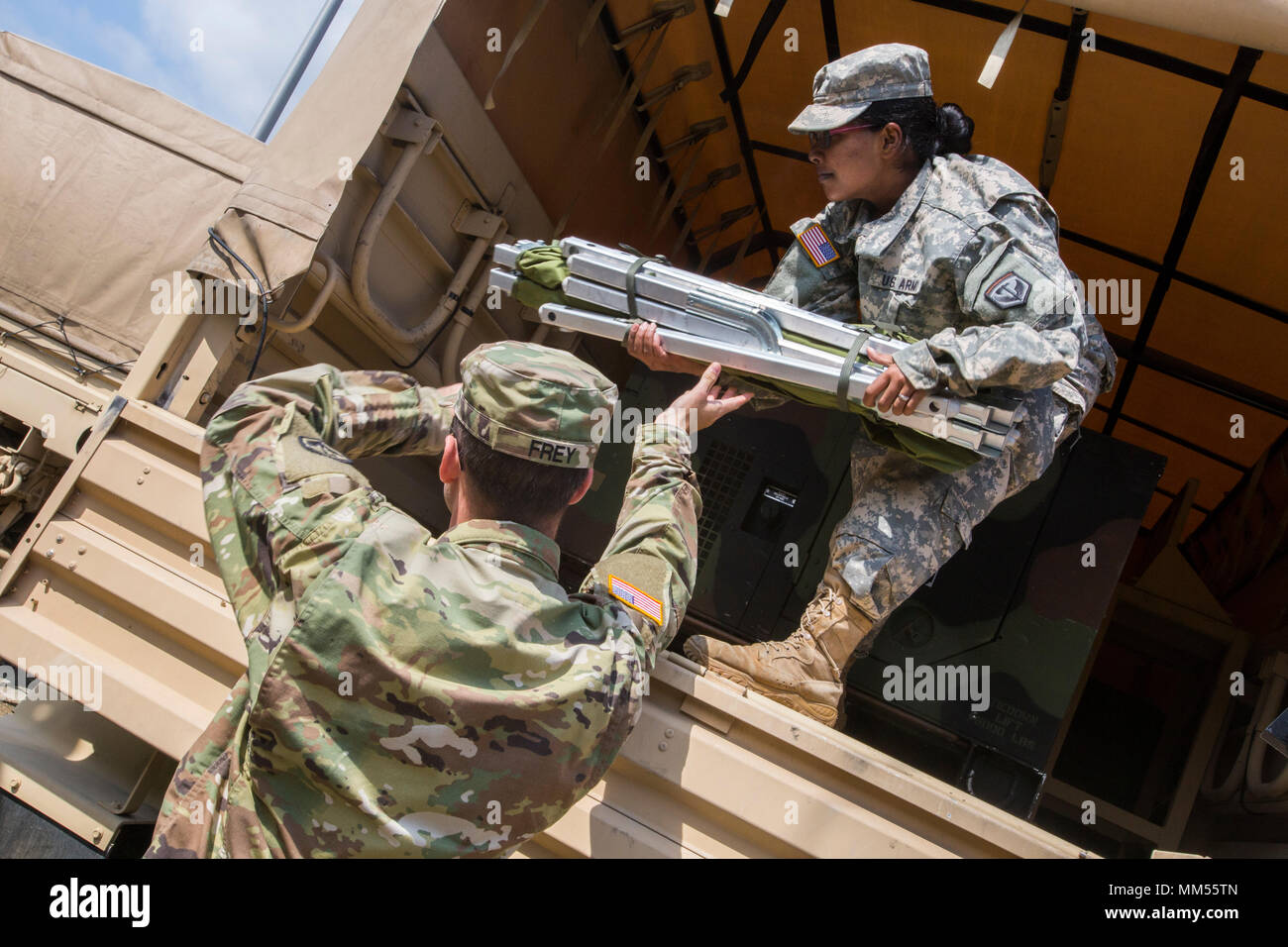 U.S. Army Soldiers with the 253rd Transportation Company load cots on