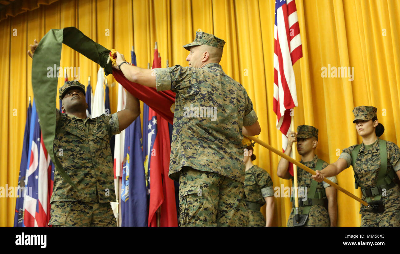 Col. Brian M. Howlett (left), commanding officer, III Marine Expeditionary Force Information Group, and Sgt. Maj. Mario P. Fields, sergeant major,  III MIG retire the III Marine Headquarters Group colors on Camp Courtney, Okinawa, Japan on Sept. 8, 2017. III MHG was re-designated in a ceremony as III MIG, highlighting the beginning of a new era of modern Marine Corps information warfare. (U.S. Marine Corps photo by Lance Cpl. Christian J. Lopez) Stock Photo