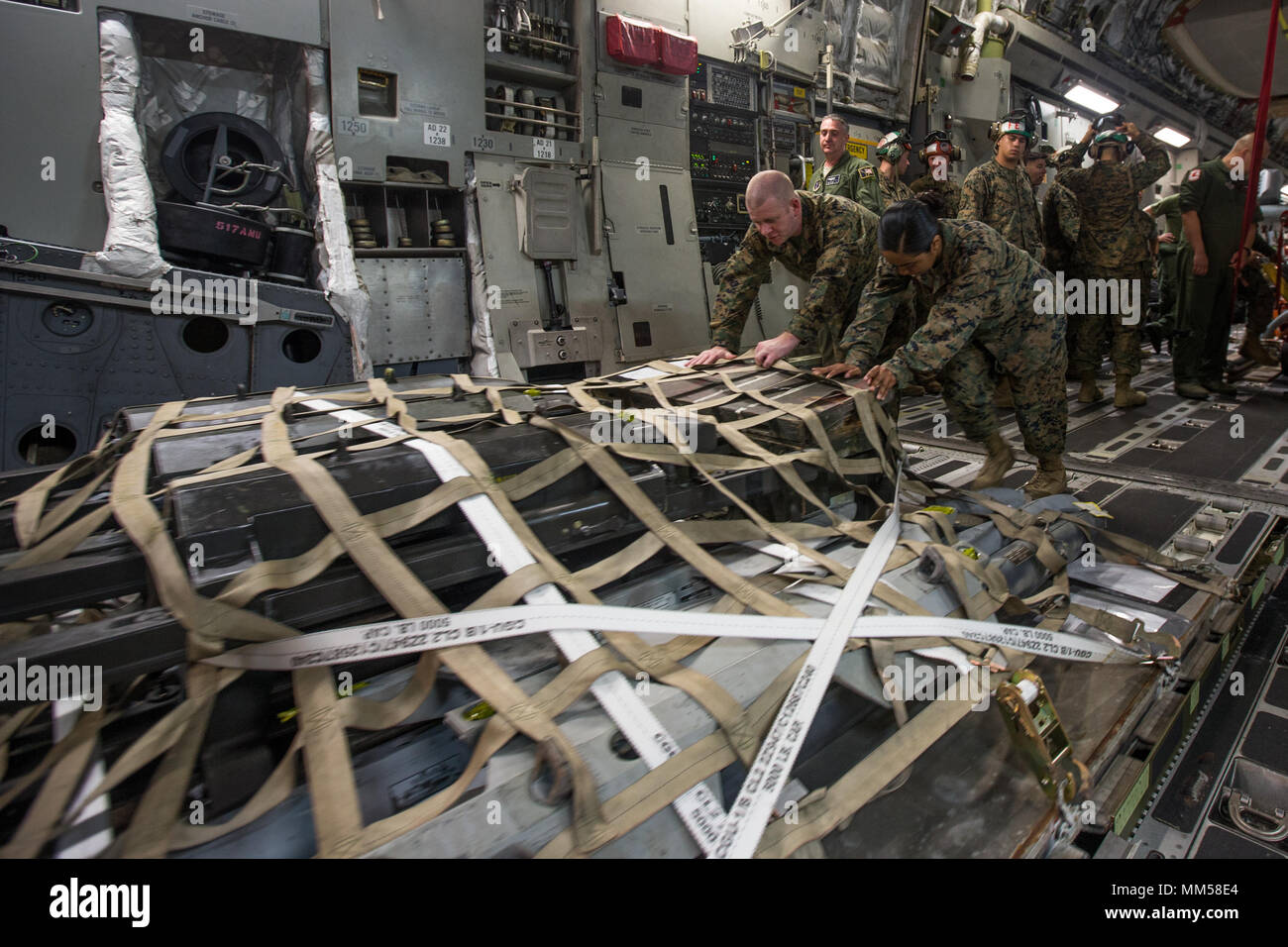 U.S. Marines with Marine Light Attack Helicopter Squadron (HMLA) 367 unload cargo from a U.S. Air Force C-17 Globemaster III during Weapons and Tactics Instructor Course (WTI) 1-18 at Marine Corps Air Station Yuma, Ariz., Sept. 6, 2017. WTI is a seven week training event hosted by Marine Aviation and Weapon Tactics Squadron (MAWTS) One cadre, which emphasizes operational integration of the six functions of Marine Corps aviation in support of a Marine Air Ground Task Force. MAWTS-1 provides standardized advanced tactical training and certification of unit instructor qualifications to support Ma Stock Photo