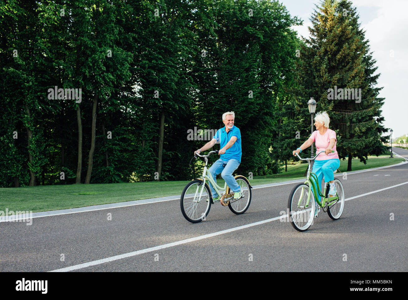 Older couple riding bicycles together Stock Photo