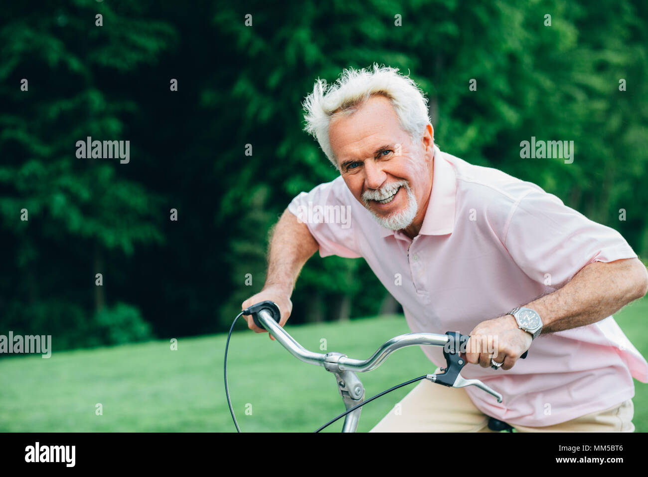 lively senior man riding his bicycle, It's a race Stock Photo