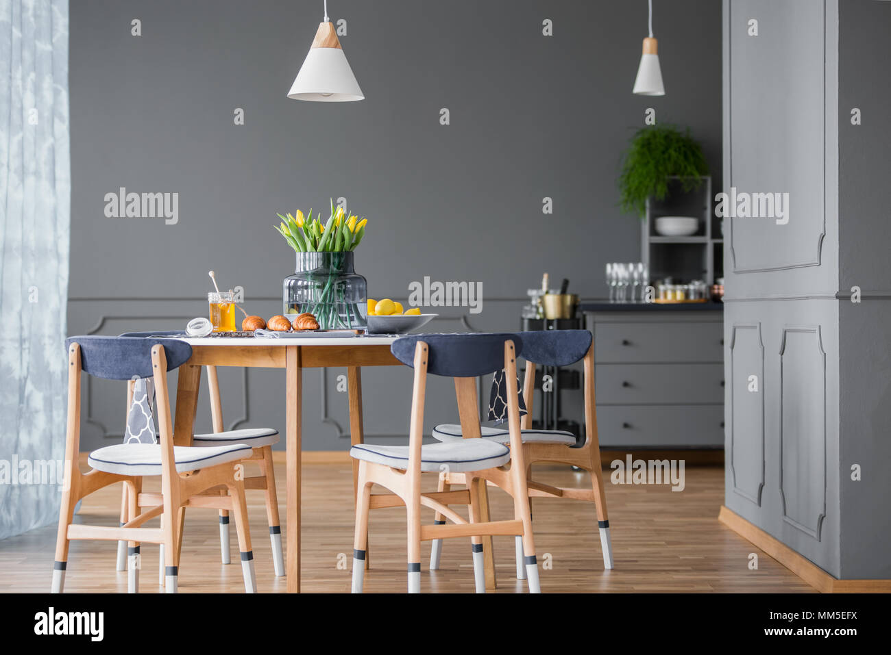 Dining table with chairs in grey kitchen interior with wooden floor Stock Photo - Alamy