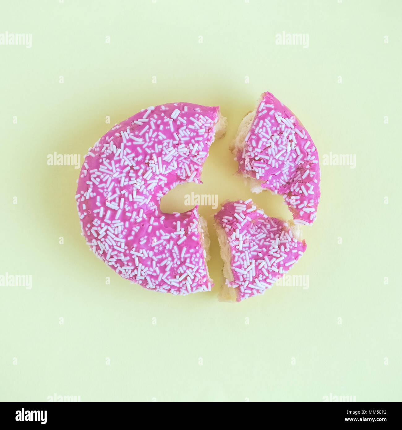 Broken donut on pastel yellow background minimal creative concept. Stock Photo