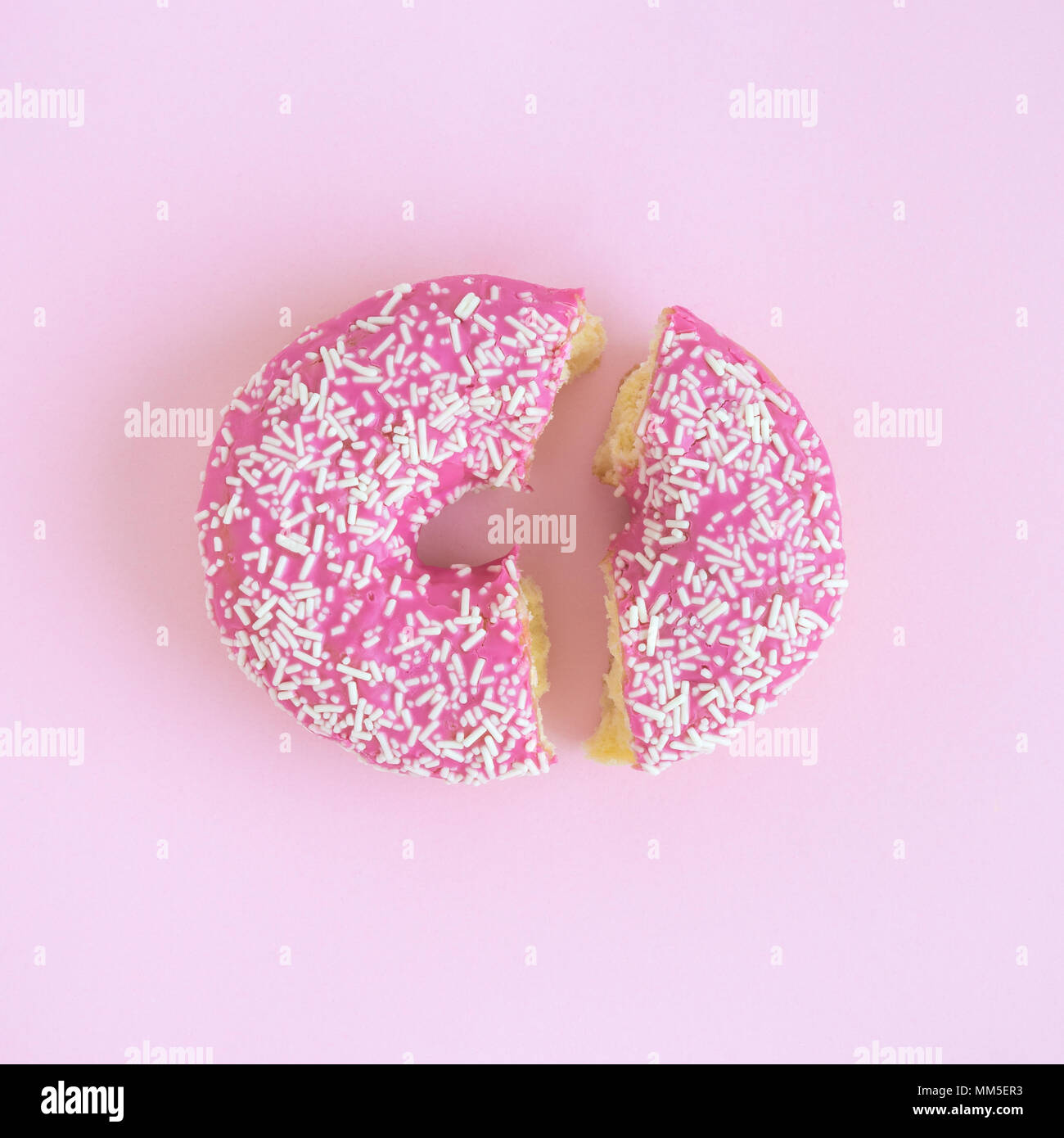 Broken donut on pastel pink background minimal creative concept. Stock Photo