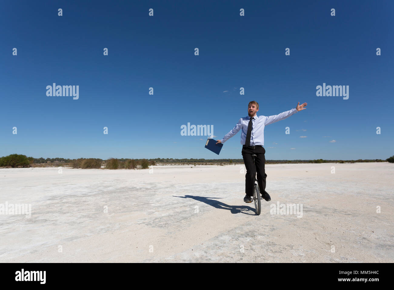 A young Businessman riding a unicycle. Business concepts. Stock Photo