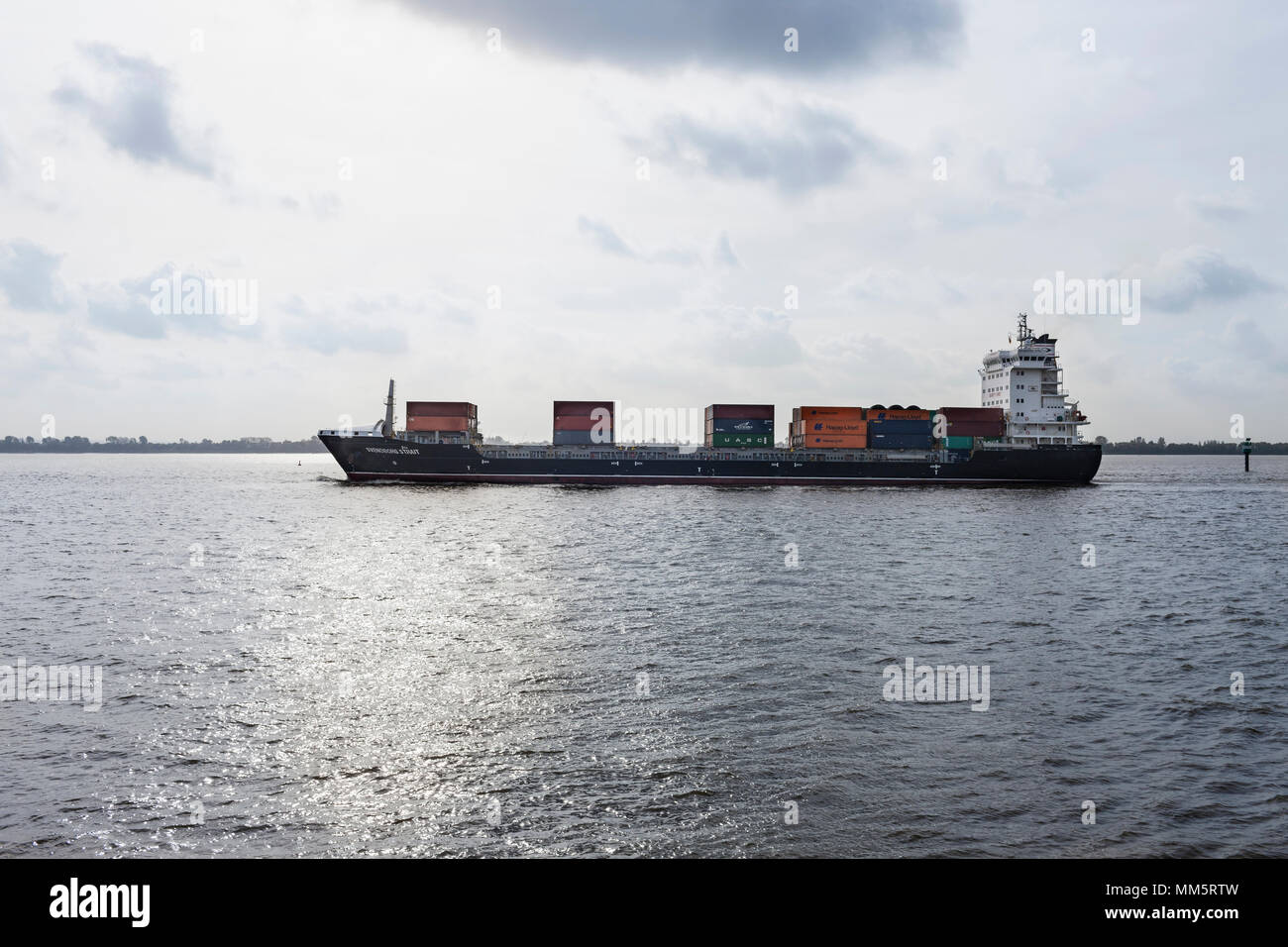 Container ship sailing on river Elbe Stock Photo