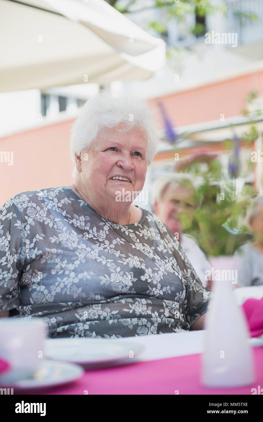Senior woman sitting at table Stock Photo