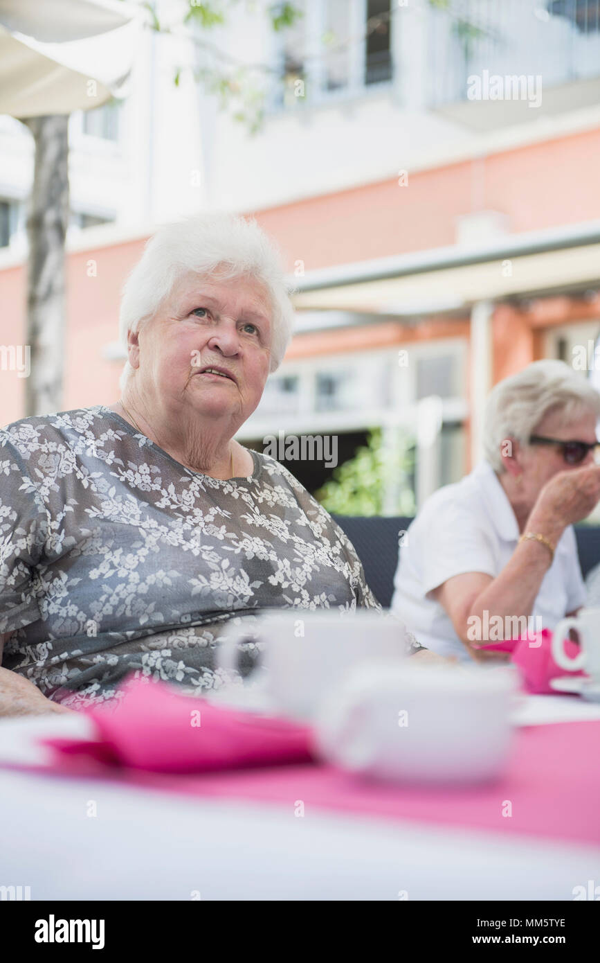 Senior woman sitting on table Stock Photo