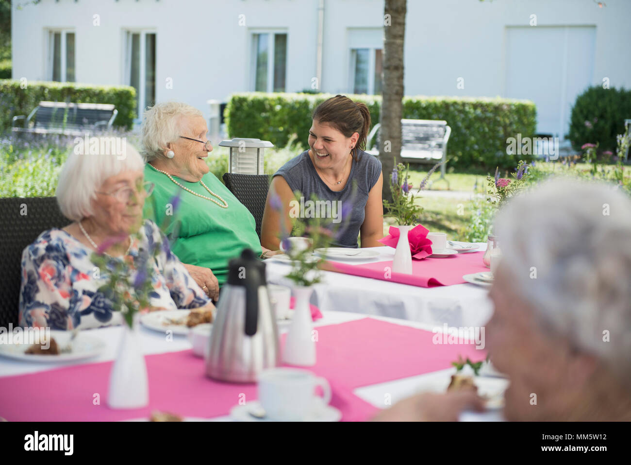 Senior women with nurse on breakfast table Stock Photo