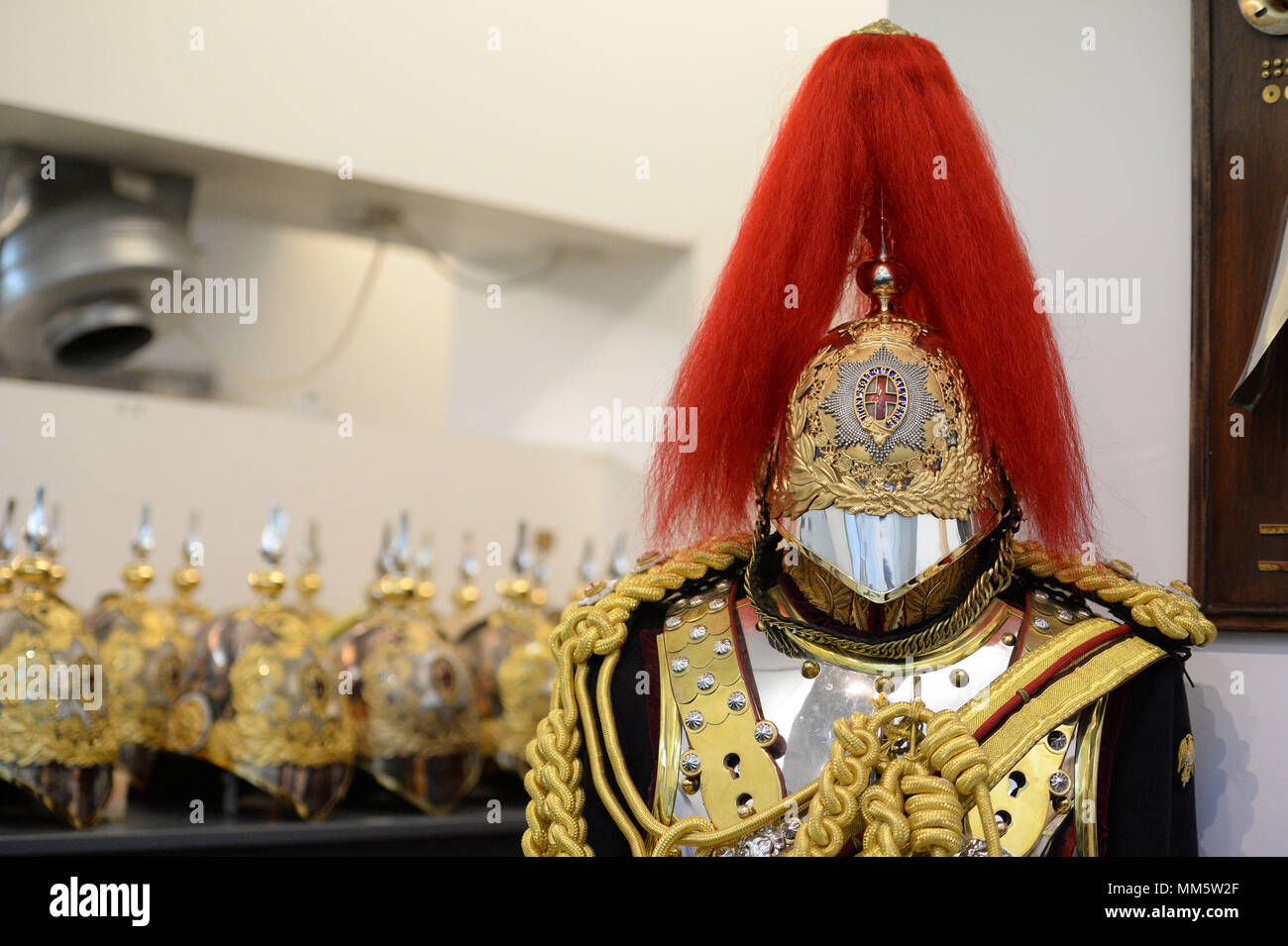A uniform and helmets in the Full Dress store during a facility to see The Household Cavalry Mounted Regiment preparations for the forthcoming Royal Wedding at Hyde Park Barracks, central London. Stock Photo