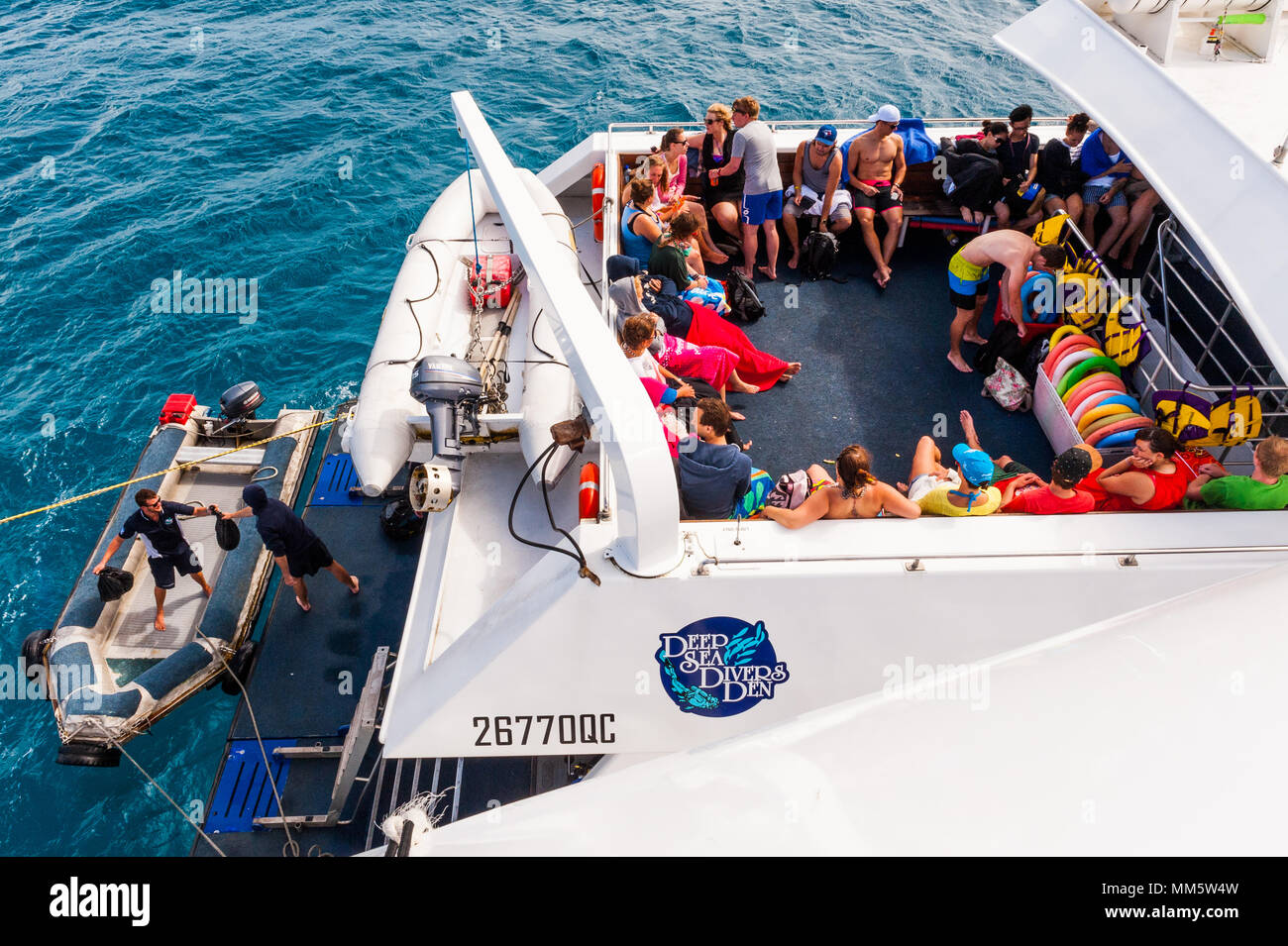 Divers relax on the deck of a live aboard dive boat between dives on