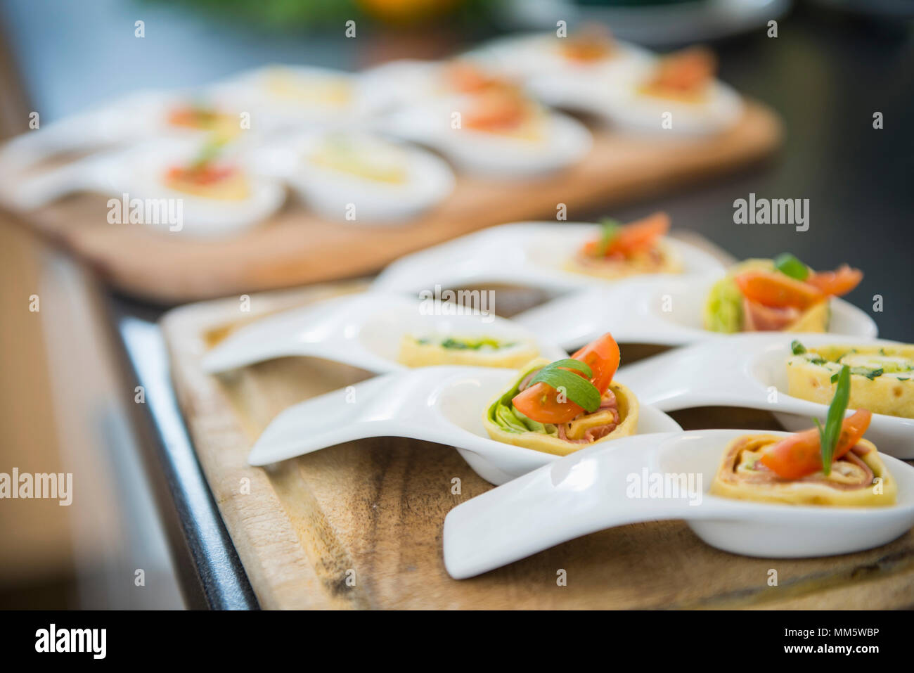 Pancake wraps as appetizers on porcelain spoons Stock Photo