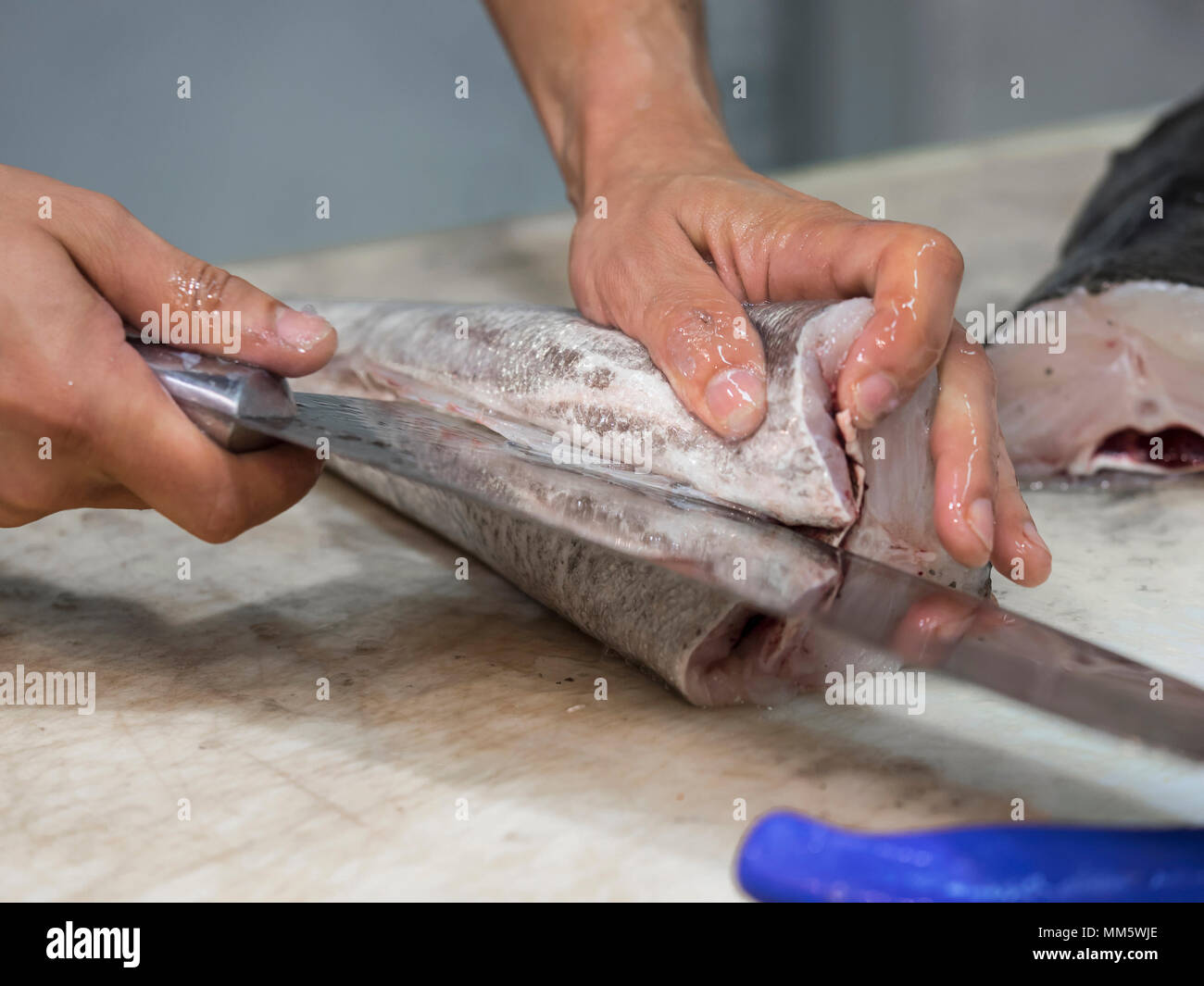 Man cutting fish with knife Stock Photo