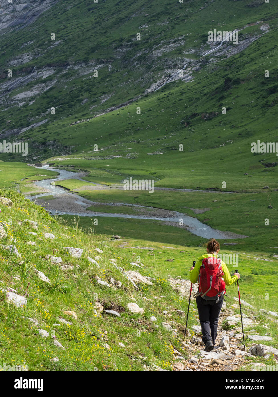 Woman hiking in the High Pyrenees descending from Hourquette d'Alans ...