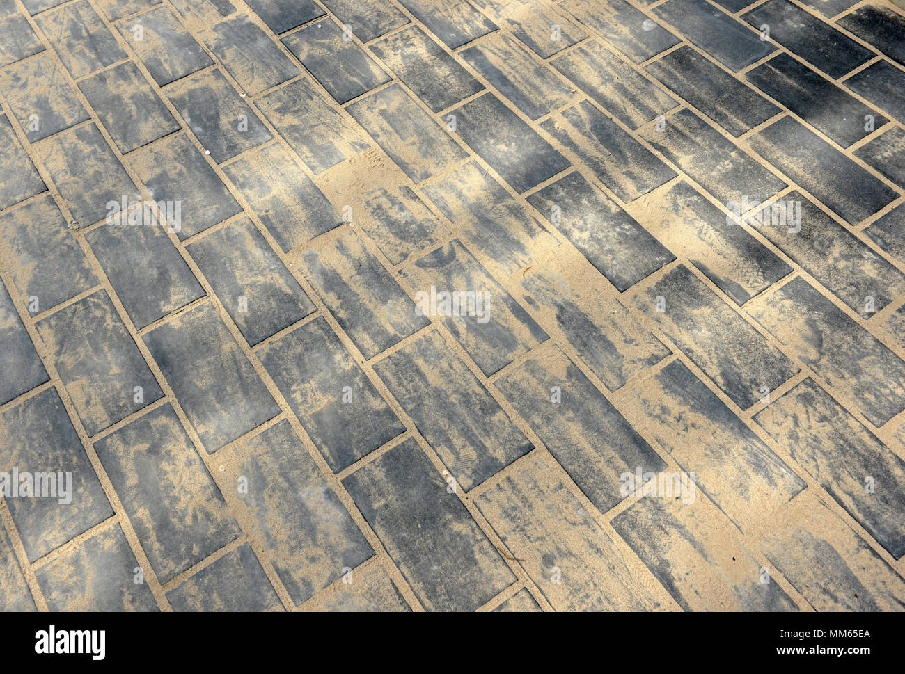 Justlaid paving bricks with sand swept into the gaps between them on a pavement in Chaoyang
