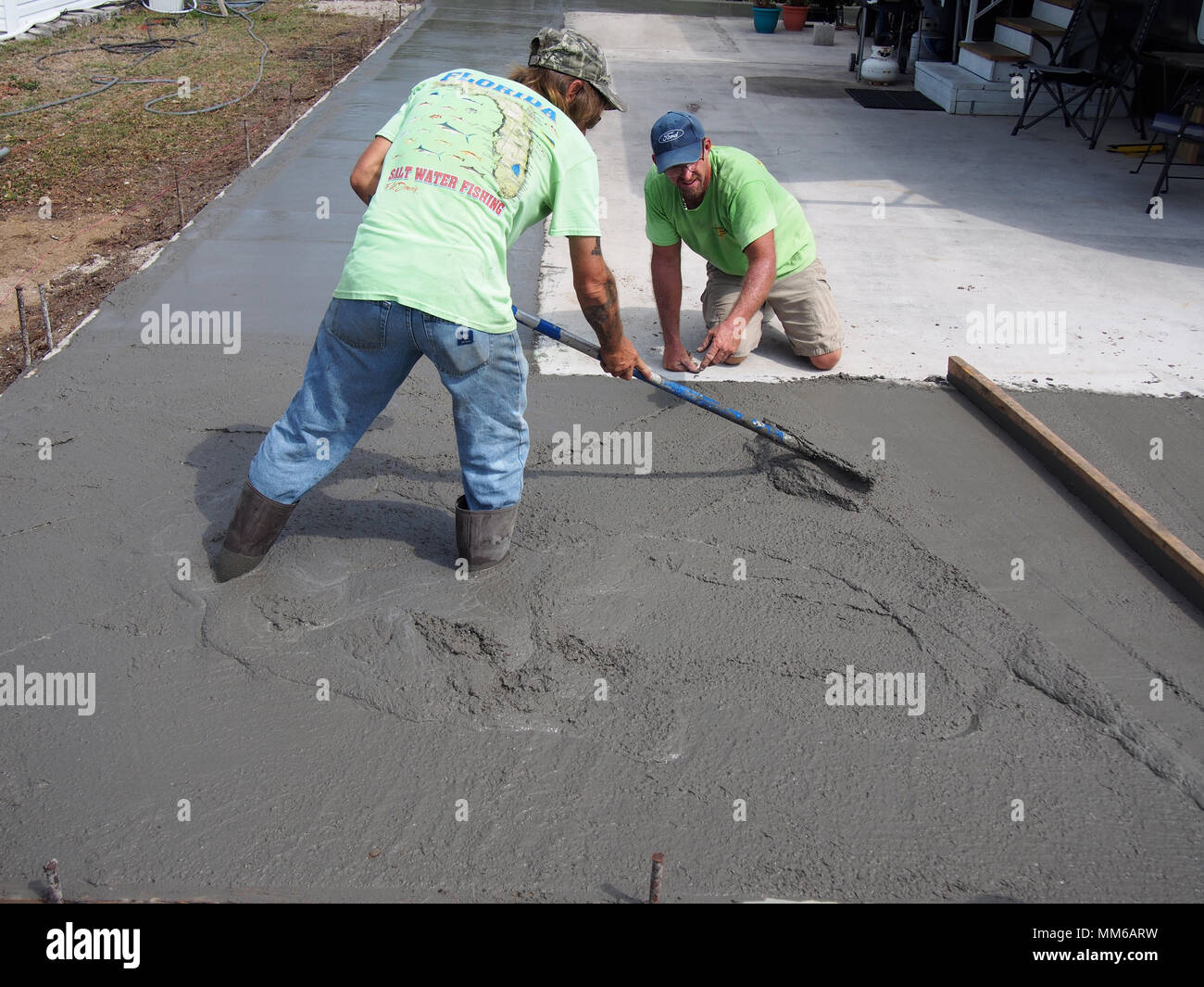 Workers spreading out and leveling freshly poured concrete, USA 2018, © Katharine Andriotis Stock Photo
