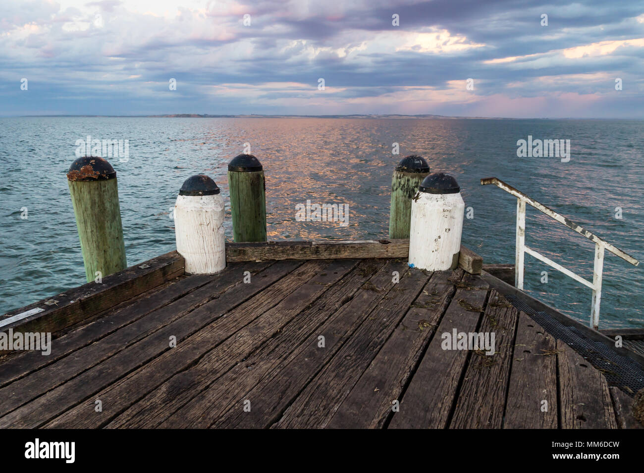 Sunset at the jetty with green and white pillars of Cowes, Phillip Island, Australia Stock Photo