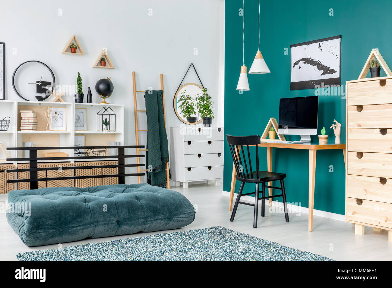 Black chair at desk with computer monitor in teenager's room interior