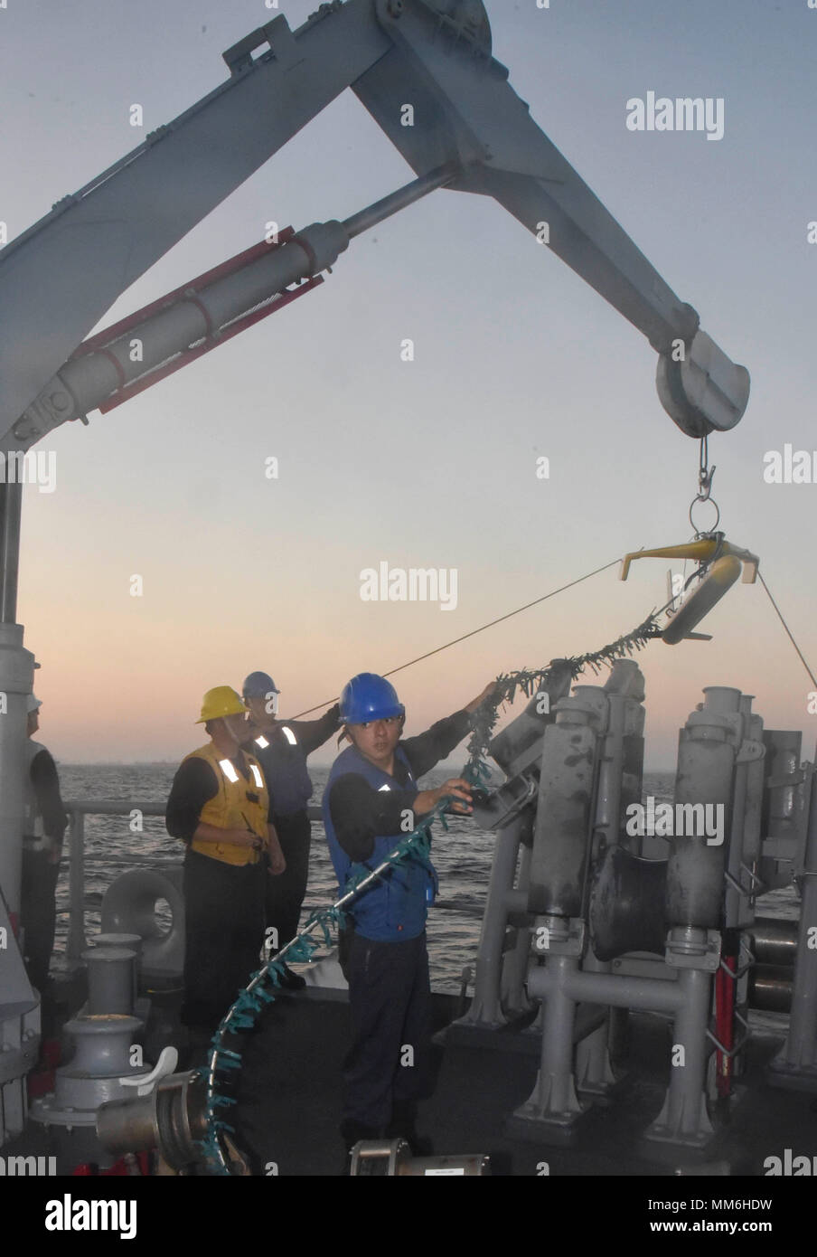 LOS ANGELES (SEPT. 7, 2017)  Sailors attached to Avenger-class mine countermeasure ship USS Champion (MCM 4) use tending lines to steady the Klein 5,000, a side-scan sonar device used to survey the ocean floor, as it is lowered into the water by an articulating crane during launch operations on the Champion fantail while off the coast of Southern California. The evolution allowed the Champion to use sonar technology in order to develop an understanding of the seabed topography.  (U.S. Navy photo by Mass Communication Specialist 2nd Class Curtis D. Spencer) Stock Photo