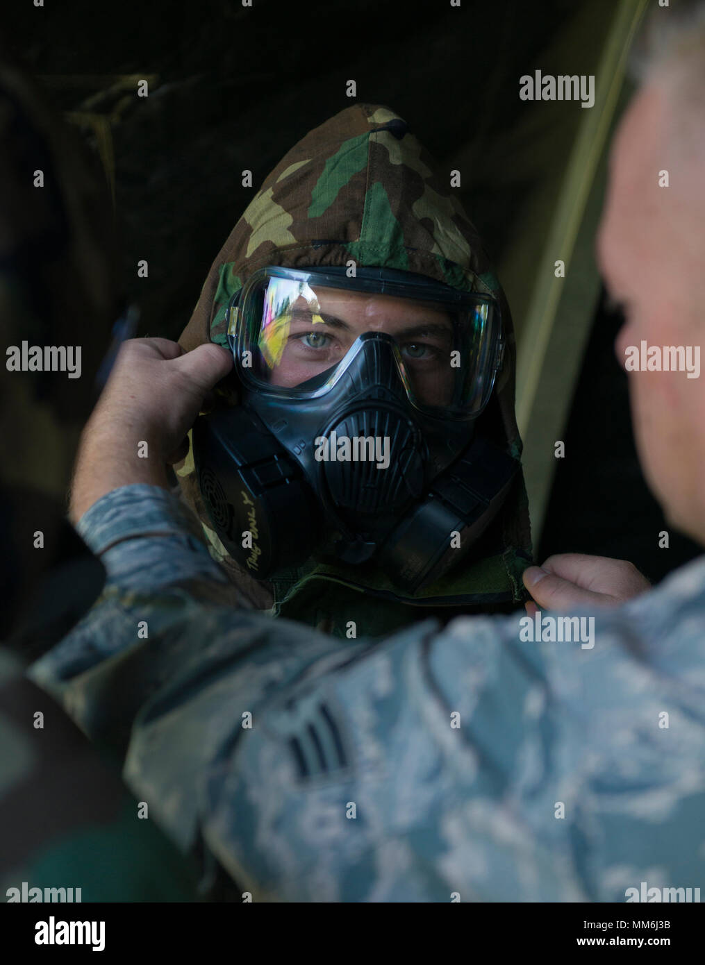 A Reserve Citizen Airman from the 914th Air Refueling Wing has his gas mask adjusted by an instructor during an annual readiness assessment, conducted at Niagara Falls Air Reserve Station, N.Y., September 9, 2017. The assessment is meant to gauge the unit's ability to operate in different protective postures (MOPP) as well as perform self aid and buddy care. (U.S. Air Force photo by Tech. Sgt. Steph Sawyer) Stock Photo