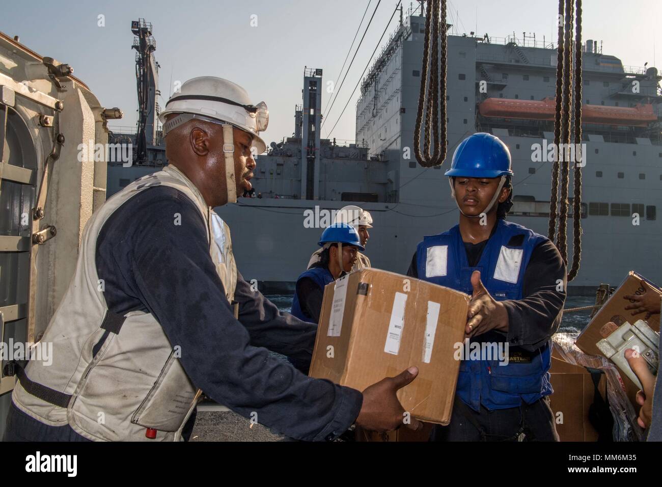 170907-N-VR594-0175 ARABIAN GULF (Sept. 7, 2017) Sailors unload supplies aboard the Ticonderoga-class guided-missile cruiser USS Princeton (CG 59) during a connected replenishment with the dry cargo and ammunition ship USNS Alan Shepard (T-AKE 3). Princeton is deployed in the U.S. 5th Fleet area of operations in support of maritime security operations designed to reassure allies and partners, and preserve the freedom of navigation and the free flow of commerce in the region. (U.S. Navy photo by Mass Communication Specialist 3rd Class Kelsey J. Hockenberger/Released) Stock Photo