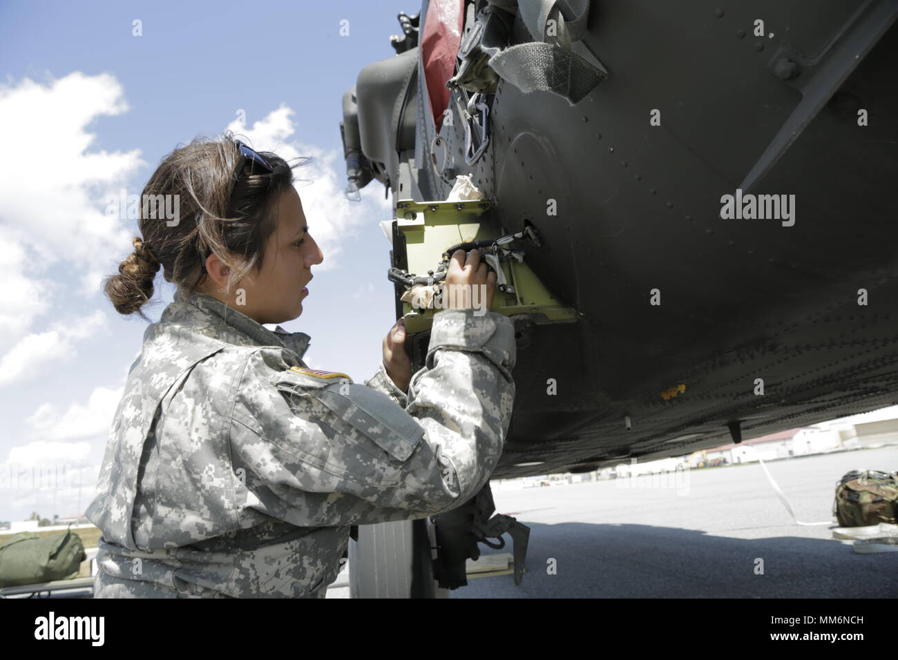 U.S. Army Pfc. Athena Tafur, Charlie Company, 6th Battalion, 101st Aviation Regiment, works on a HH-60M, Patrick Airforce Base, Fl., Sept. 12, 2017. Soldiers stage helicopters in preparation for medical operations in the Hurricane Irma relief process.  (U.S. Army photo by Pfc. Joseph Cannon) Stock Photo